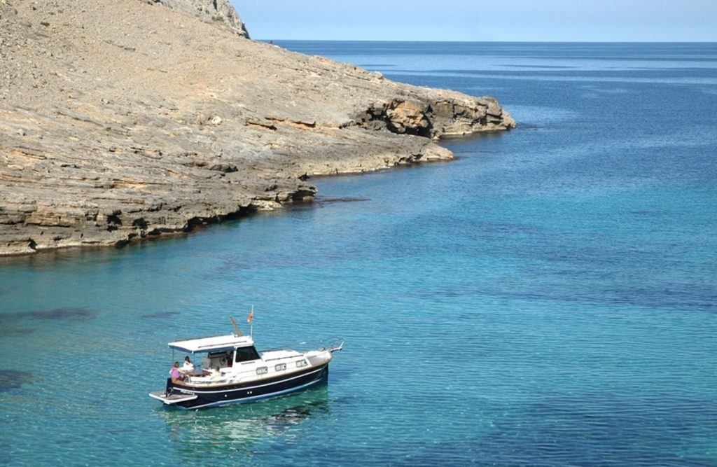 Solo traveler exploring Mallorca's hidden coves on a boat excursion.